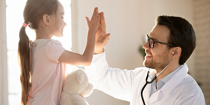 A Boston Children's Hospital doctor giving a high five to a female patient.